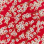 Roter Stoff mit weißen Blüten und Goldzweige